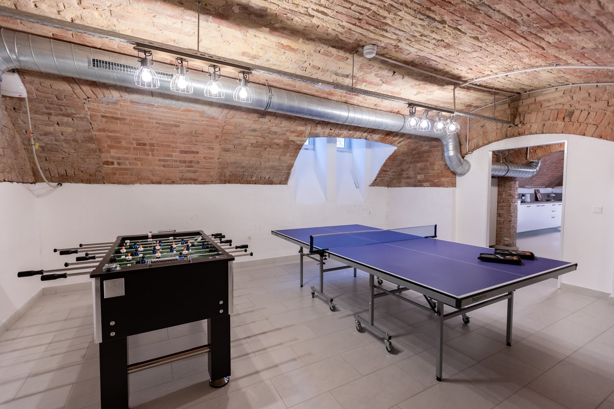 The residents' games room in the vaulted basement, with table tennis and table football